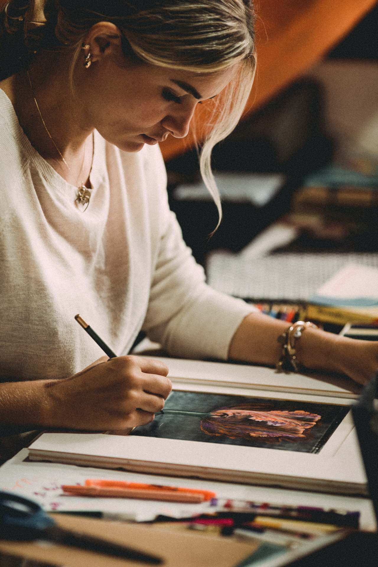 woman drawing a flower with colored pencils