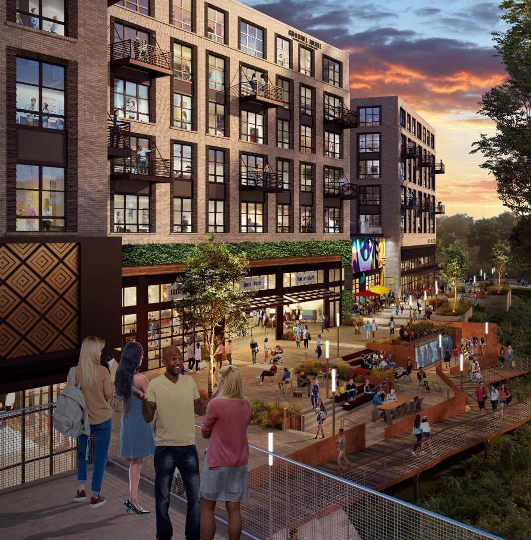 people standing on a balcony overlooking a large mixed use courtyard.